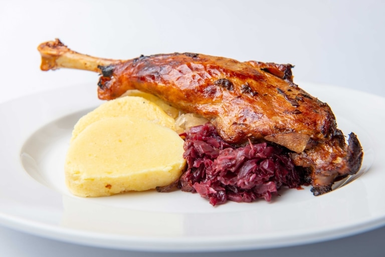 Baked duck leg with potatoes and red cabbage.